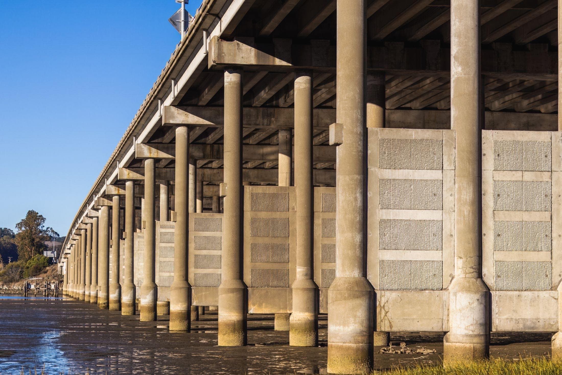 The underside of a concrete road bridge receding in perspective