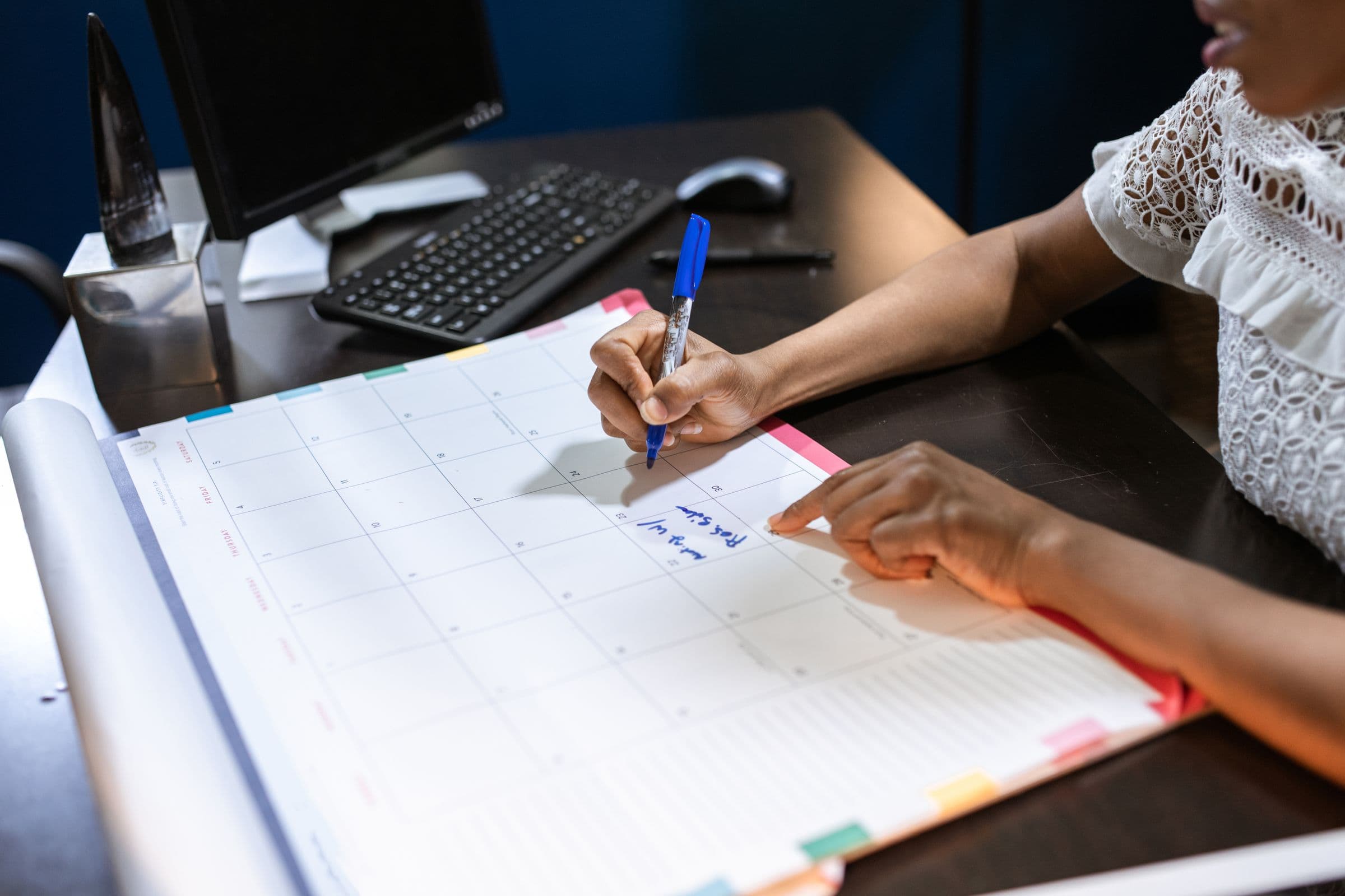 A hand writing on a desk calendar